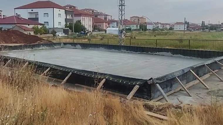 Şarkışla'da inşaatı devam eden bir gazilhane binasının temeli, çevresinde boş alan ve binalar görünmekte.