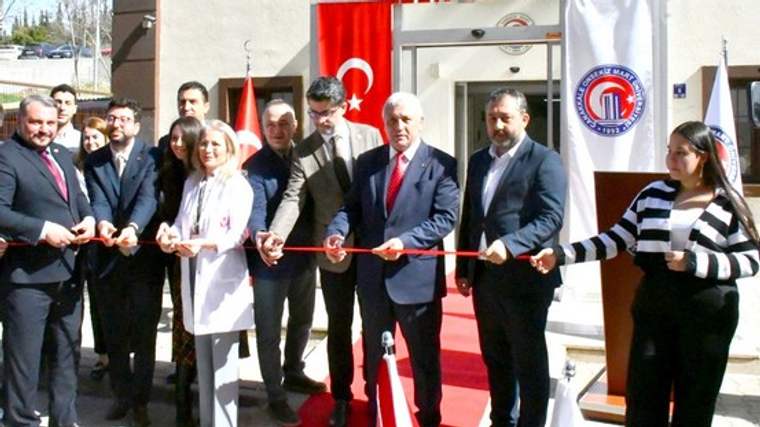 Nükleer Tıp Merkezi girişinde, aralarında beyaz önlüklü bir kişinin de bulunduğu grup kırmızı kurdele kesiyor.