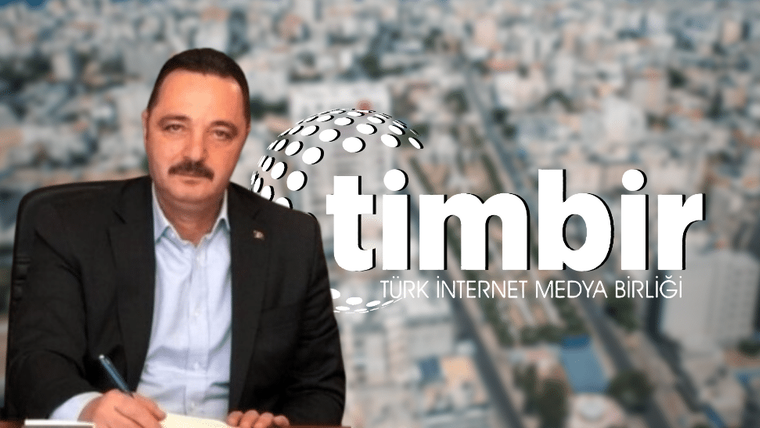Bir kişi, masanın üzerinde not alırken arka planda şehir manzarası görünmekte.
