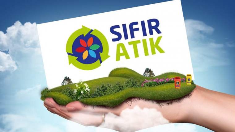 Bir elin üzerinde yeşil bir tepe ve çiçekler var, tepenin üzerinde "SIFIR ATIK" yazılı bir tabela duruyor.