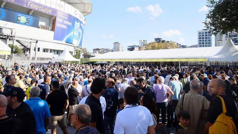 Fenerbahçe yazılı stadyum binası önünde, açık alanda toplanan kalabalık görülüyor.