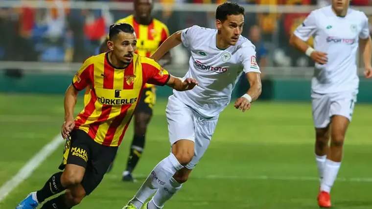 Konyaspor ve Göztepe futbolcuları, sahada top peşinde koşuyor.
