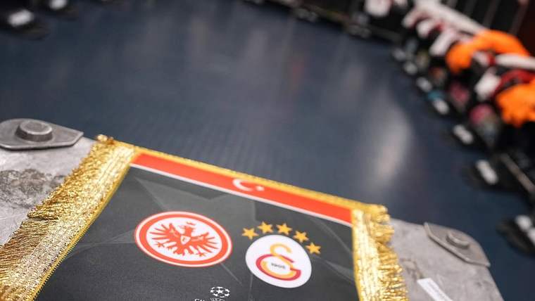 Üzerinde Eintracht Frankfurt ve Galatasaray armaları bulunan, altın püsküllü siyah bir bayrak görülüyor.