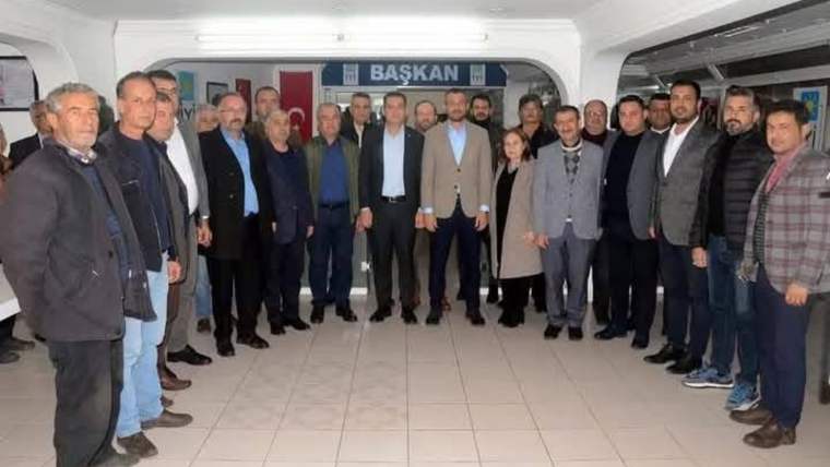 İyi Parti binasında bir araya gelen Ak Parti Serik İl Teşkilatı üyeleri, grup halinde poz veriyor.
