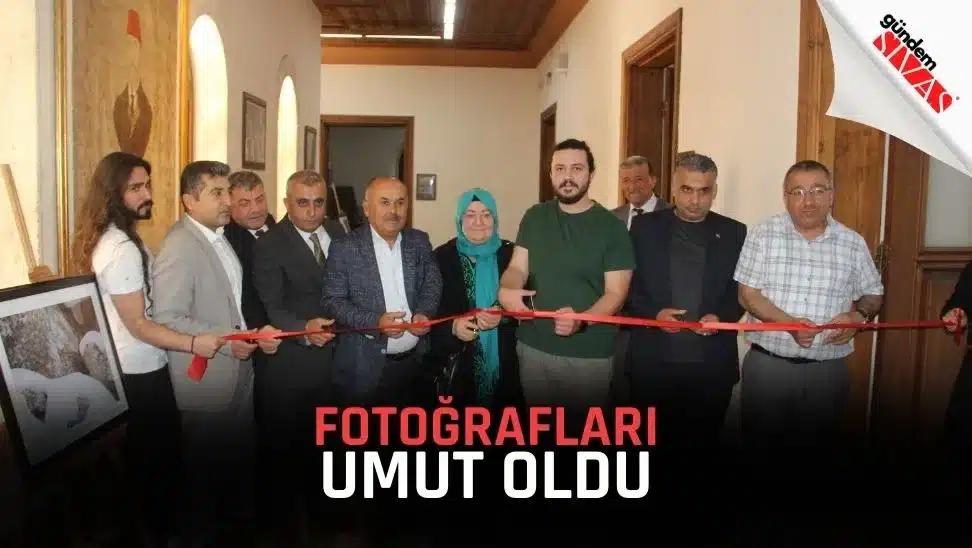 İç mekânda bir grup kişi, ellerindeki makaslarla kırmızı kurdeleyi keserken yan yana duruyor.