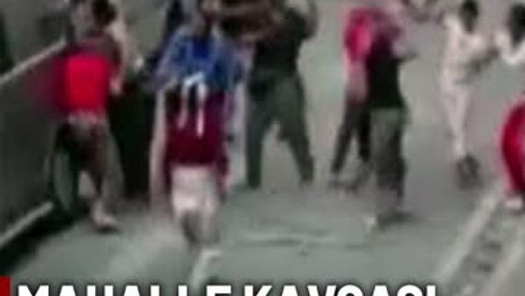 Sopalar ve taşlarla kavga eden iki grup insan, sokakta karşı karşıya gelmiş.