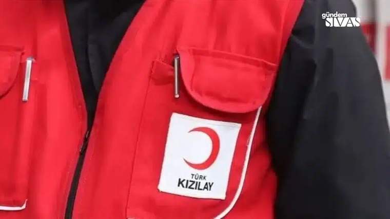 Kırmızı bir yelek giymiş bir kişinin üzerinde Türk Kızılayı logosu bulunuyor.