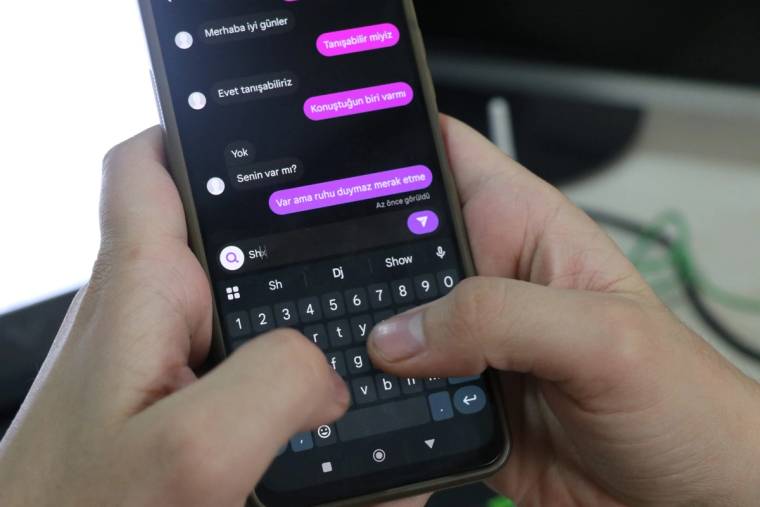 Bir kişinin akıllı telefonunda mesajlaşma uygulaması açık, parmakları klavyede yazı yazıyor.