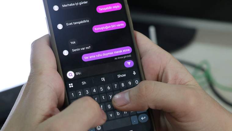 Bir kişinin akıllı telefonunda mesajlaşma uygulaması açık, parmakları klavyede yazı yazıyor.