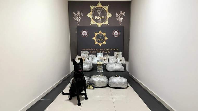 RNP amblemi önünde, poşetlenmiş maddeler ve yanlarında oturan görev köpeği görülüyor.