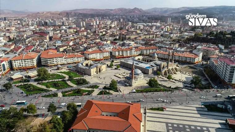 Sivas'ın tarihi yapıları ve modern binalarının yer aldığı bir şehir manzarası.