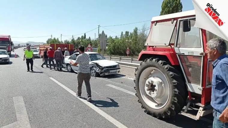 Bölünmüş yolda ön kısmı hasarlı bir otomobil, traktör ve çevresinde duran insanlar görülüyor.