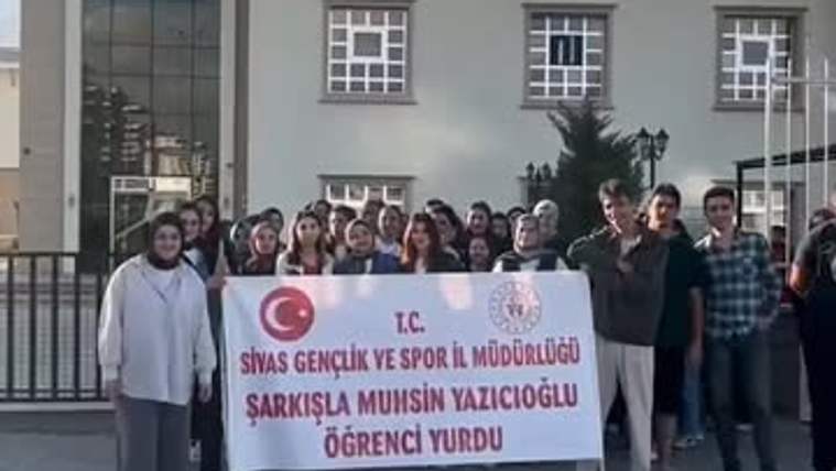 Bir grup genç, üzerinde Sivas Gençlik ve Spor Müdürlüğü ile öğrenci yurdu yazan pankartı tutuyor.