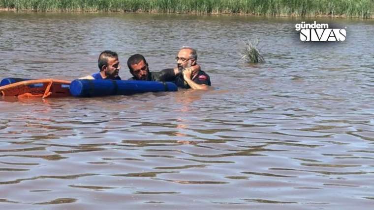 Kızılırmak nehrinde suya girmiş bir adam, kurtarma ekipleri tarafından destekleniyor.