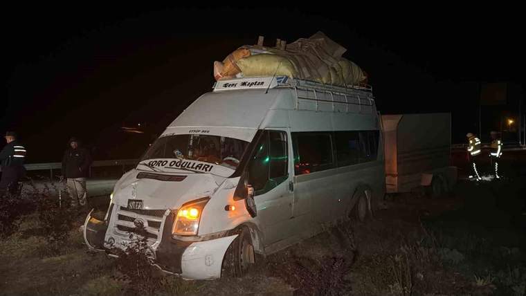 Gece karanlığında, ön kısmı hasar görmüş yük yüklü bir minibüs yol kenarındaki arazide duruyor.
