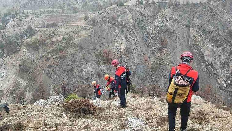 Dağlık alanda, arama ve kurtarma ekipleri, kask ve özel giysilerle yürüyüş yapıyor.