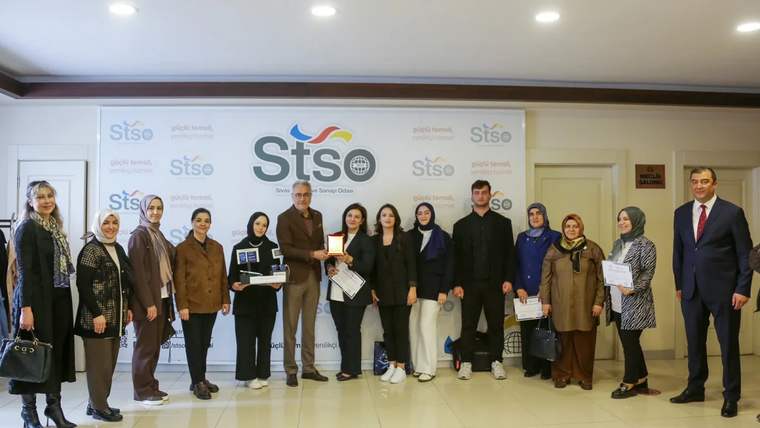 Atölye katılımcıları, sertifikalarını alırken bir arada poz veriyorlar.