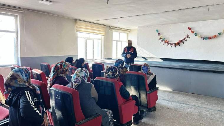 Bir salonda başörtülü kadınların oturduğu sıraların önünde kürsüde konuşan bir kişi görülüyor.