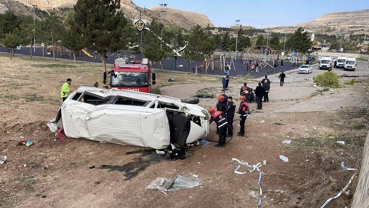Ters dönmüş beyaz bir minibüs, çevresinde kurtarma ekipleri ve itfaiye aracı var.