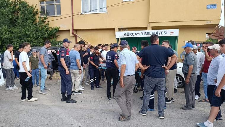 Gürçayır Belediyesi tabelası önünde, üniformalı görevliler ve vatandaşlardan oluşan bir grup bekliyor.