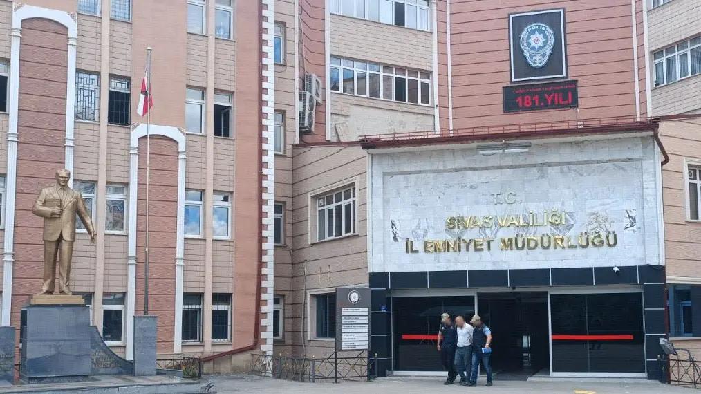Sivas Valiliği İl Emniyet Müdürlüğü binasının önünde, üç kişi yürüyerek çıkıyor.