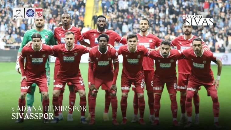 Kırmızı formalar giyen futbolcular, tribünlerdeki seyircilerin önünde takım halinde poz veriyor.