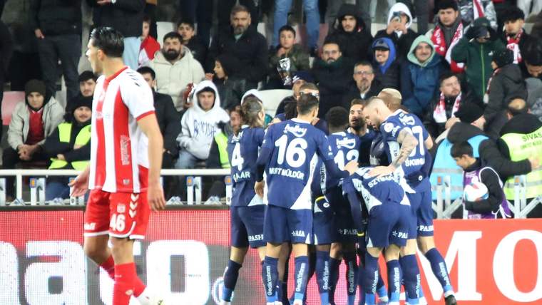 Sivassporlu futbolcular, gol sonrası sevinç yaşıyor; arka planda kalabalık bir seyirci grubu var.