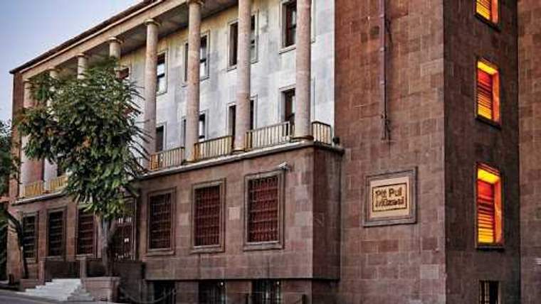 Taş kaplamalı, sütunlu binanın duvarında “Pul Müzesi” yazılı bir tabela görülüyor.