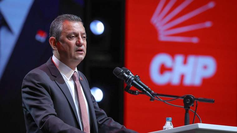 CHP logosunun arkasında bir kürsüde konuşan bir kişi, mikrofonun önünde duruyor.