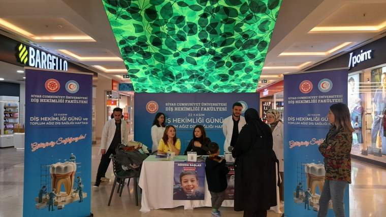 Cumhuriyet Üniversitesi Diş Hekimliği Fakültesi standında, diş sağlığı hakkında bilgi veren kişiler ve ziyaretçiler yer alıyor.
