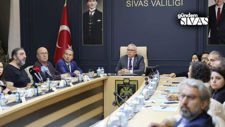 Sivas Valiliği toplantı salonunda, masada oturan katılımcılar ve arka planda Türk bayrağı ile valilik logosu görünmektedir.