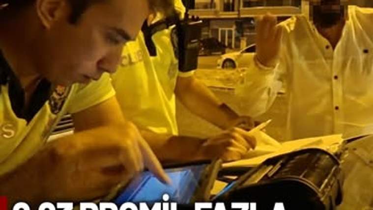 Polis memurları, alkollü sürücüye ceza keserken bir tablet üzerinde işlem yapıyor.