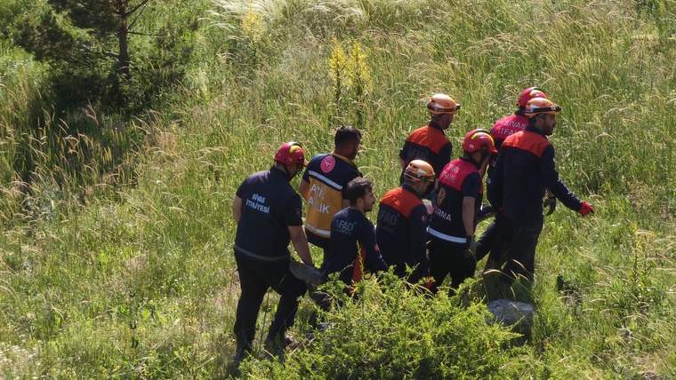 Kaza bölgesinde, kurtarma ekipleri yeşil alanda yürüyüş yapıyor.