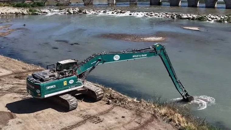 Kızılırmak Nehri kıyısında çalışan bir ekskavatör, suyun içinden malzeme alıyor.