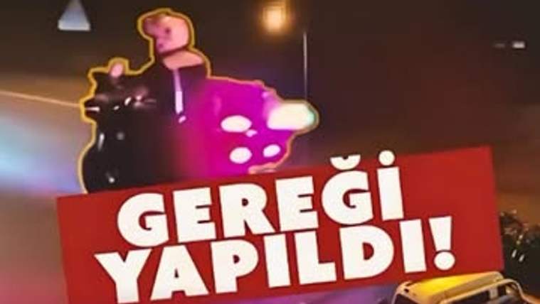 Gece çekiminde motosiklet kullanan bir kişi, kırmızı “Gereği Yapıldı!” yazılı bant ve bir araçla görülüyor.