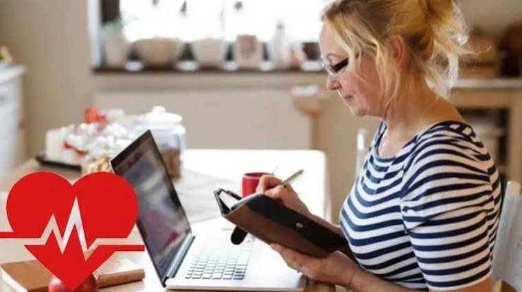 Çizgili tişört giyen bir kadın, dizüstü bilgisayarın yanında tablet üzerinde kalemle işlem yapıyor.