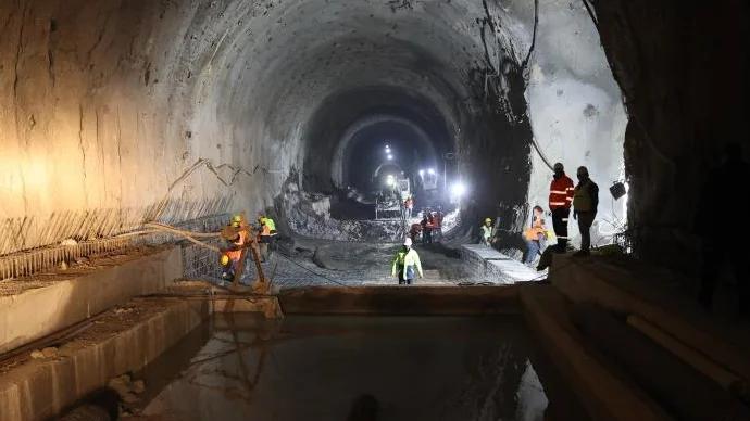 Geminbeli Tüneli inşaatında çalışan işçiler, tünel içinde çeşitli ekipmanlarla çalışıyor.