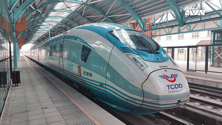 Mavi-beyaz renkte bir yüksek hızlı tren, istasyonda bekliyor.