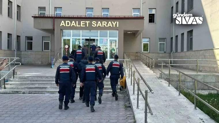 “Adalet Sarayı” yazılı bina girişine doğru yürüyen, koyu renk üniformalı birkaç görevli görülüyor.