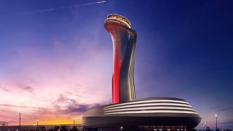 Gün batımında, kıvrımlı tasarıma sahip havalimanı kulesi ve geniş terminal binası görülüyor.
