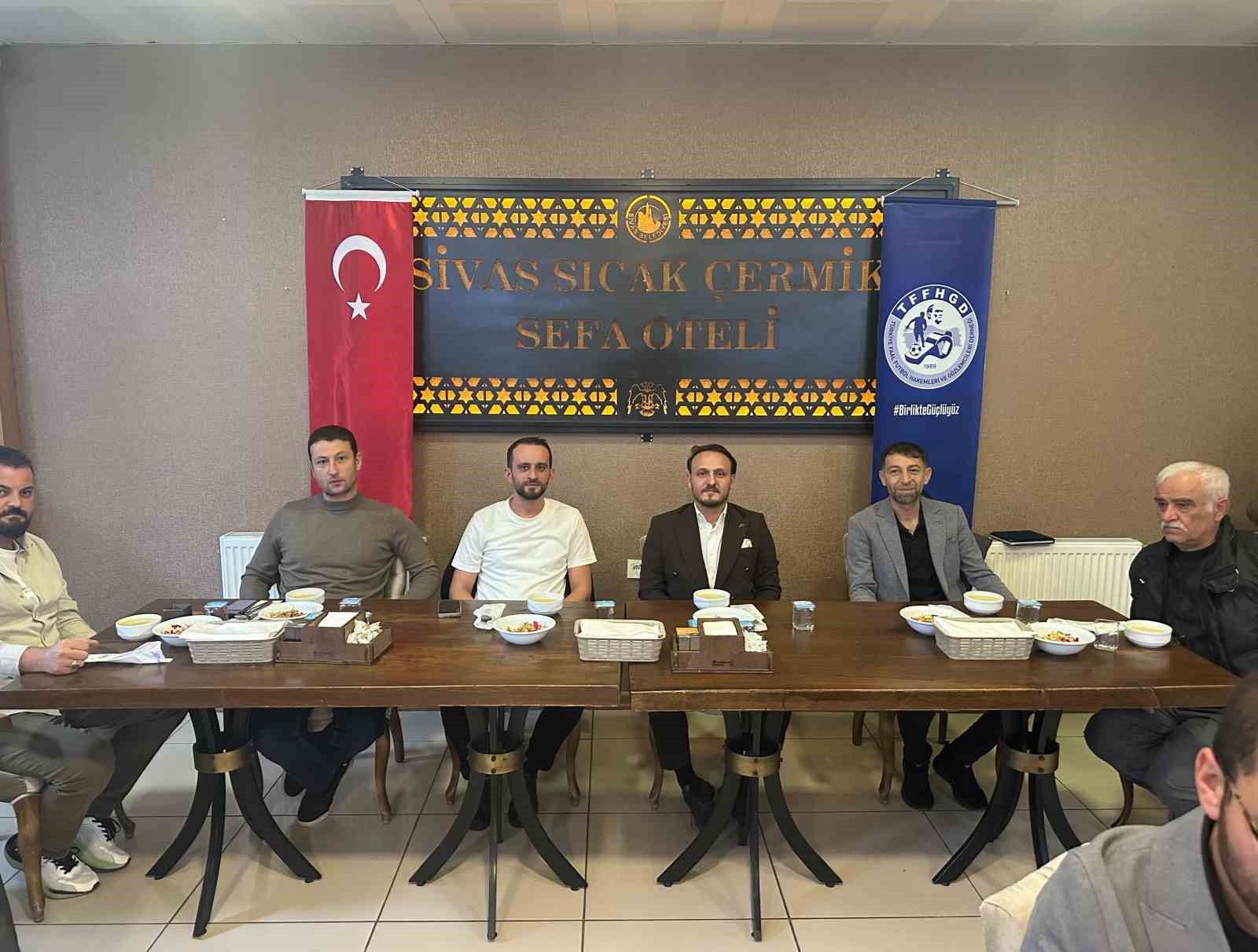 Bir otelde masada oturan kişiler, arkalarında Türk bayrağı ve üzerinde Sivas Sıcak Çermik Sefa Oteli yazılı pankartla görülüyor.