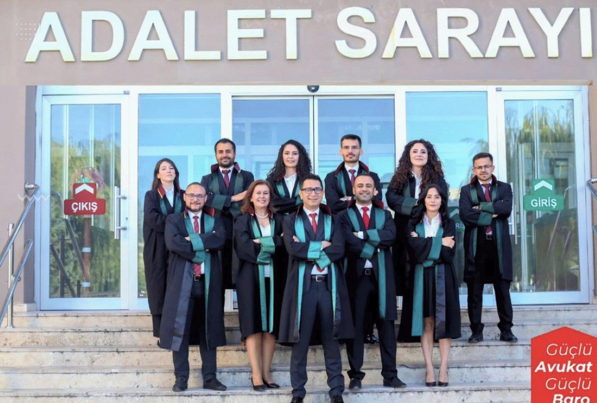 Adalet Sarayı girişinde, üzerinde cübbe bulunan bir grup kişi basamaklarda birlikte duruyor.
