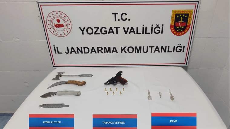Yozgat Valiliği İl Jandarma Komutanlığı tabelası önünde tabanca, fişek, kesici aletler ve payp sergileniyor.