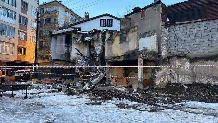 Çökmüş bir metruk bina, etrafında kar ve molozlar var, bina önünde güvenlik şeridi çekilmiş.