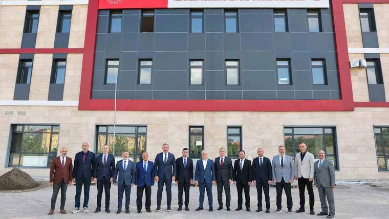 Üzerinde Gençlik ve Spor Bakanlığı tabelası bulunan binanın önünde bir grup kişi yan yana duruyor.