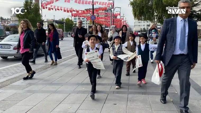 Cumhuriyet'in 100. yılı için yürüyüş yapan çocuklar, ellerinde pankartlarla ilerliyor.