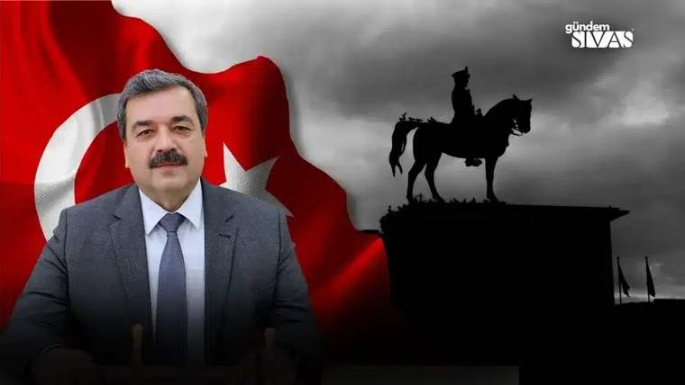 Takım elbiseli bıyıklı bir adam, Türk bayrağı ve at üstündeki heykel silüeti önünde görülüyor.