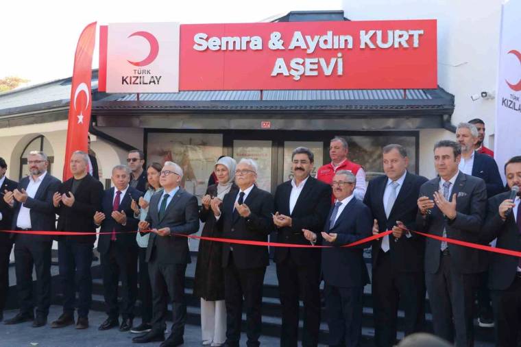 “Semra & Aydın Kurt Aşevi” tabelası önünde, kırmızı kurdele arkasında duran bir grup kişi görülüyor.