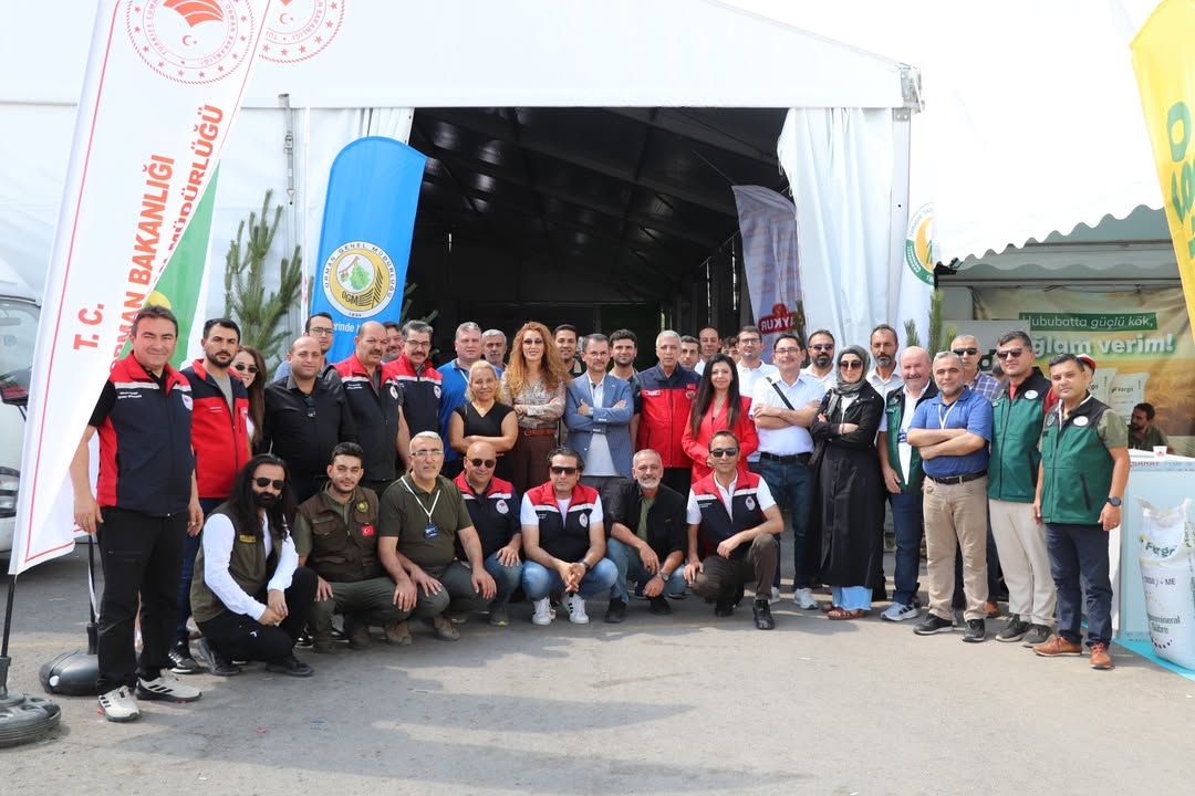 Agro Sivas Fuarı'nda katılımcılar, stant önünde topluca poz veriyor.