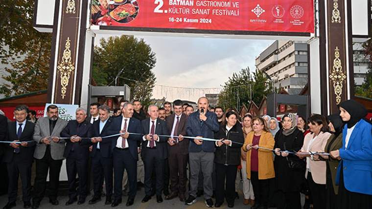 Kurdele kesen kalabalık, festival girişinde bir kişi konuşma yapıyor.